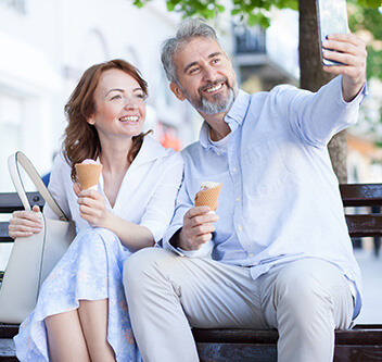 Mature couple eating ice cream and posing for selfie